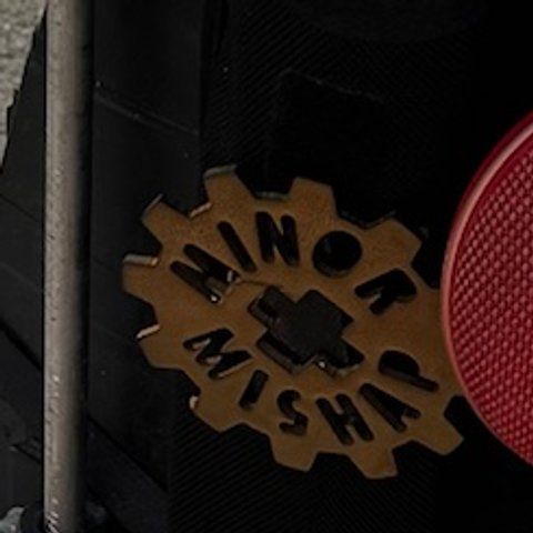 A gear-shaped Minor Mishap badge on the harness.