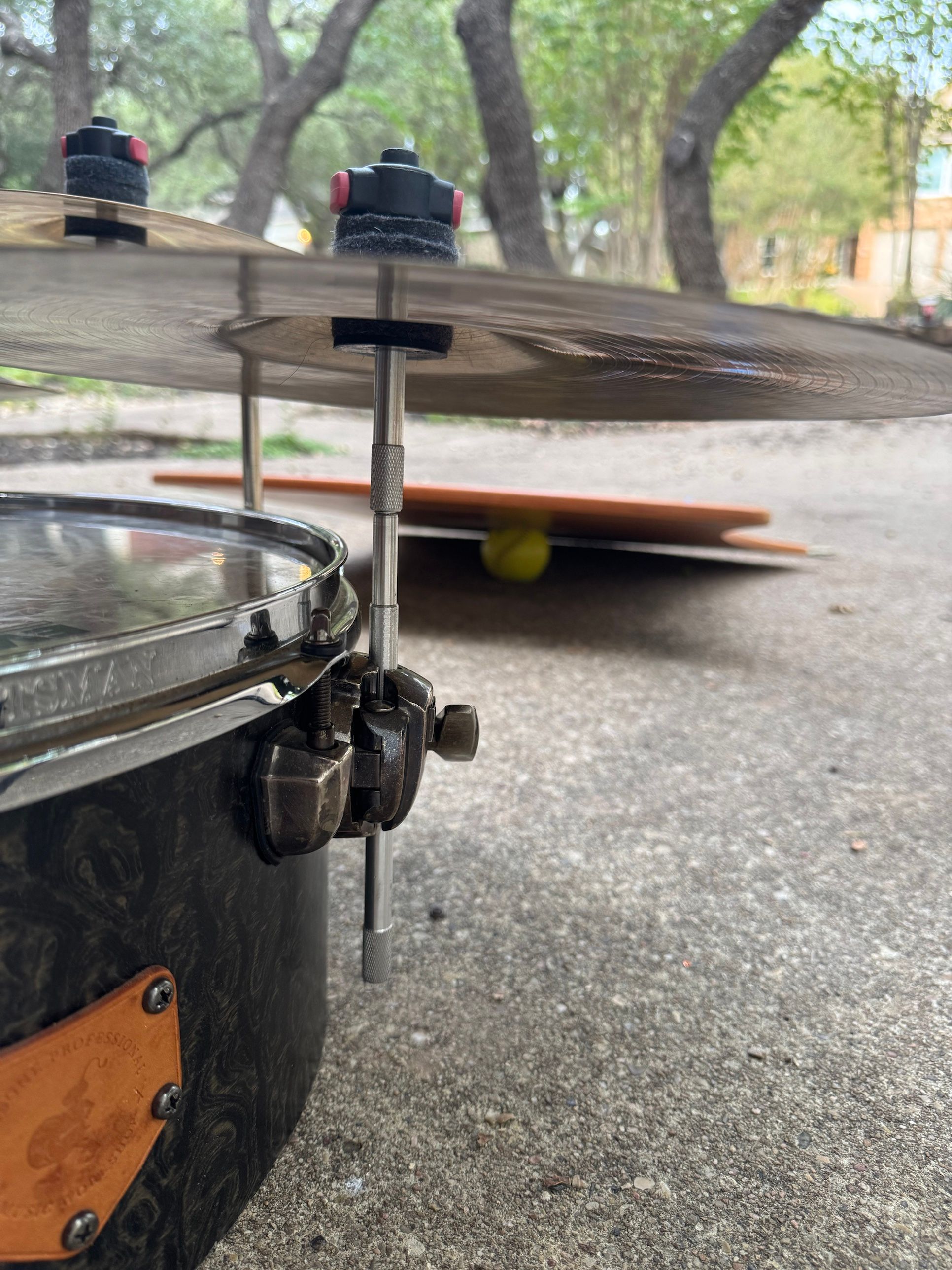A straight cymbal stacker rod standing in the floor tom’s leg mount, holding a cymbal above the drum.