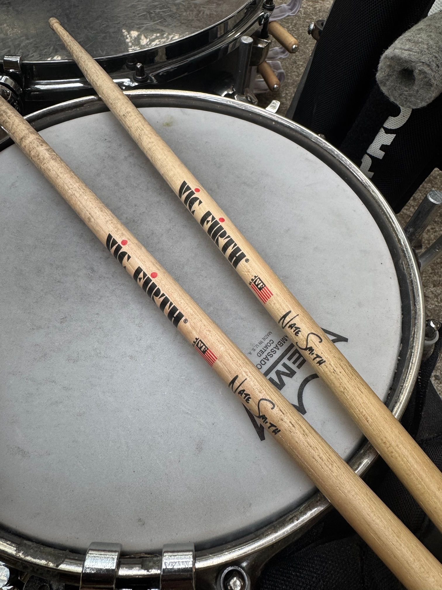 Two Vic Firth Nate Smith signature drumsticks lying across the snare head.